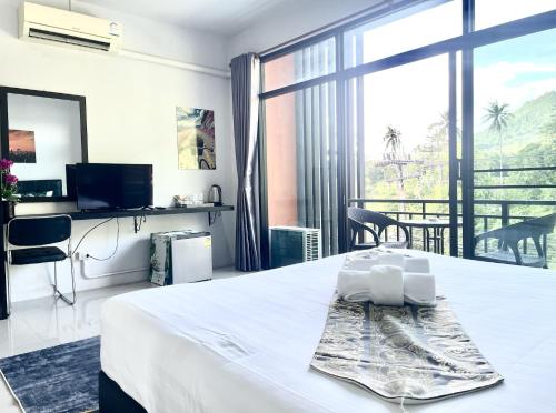 a hotel room with a bed and a large window at Mr.T Kamala Room in Kamala Beach