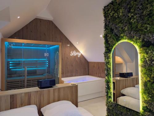 ein Badezimmer mit Badewanne und großem Fenster in der Unterkunft Escale Lomy en bord de mer avec Sauna et Jacuzzi in Pléneuf-Val-André