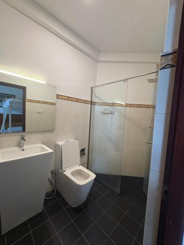 a bathroom with a toilet and a shower and a sink at Kandy Krush Hostel in Kandy