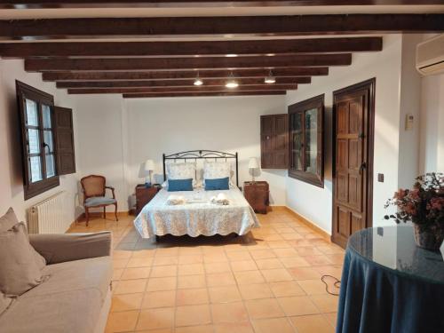 ein Schlafzimmer mit einem Bett und einer Couch in einem Zimmer in der Unterkunft Casona Arquillo del Judío in Toledo