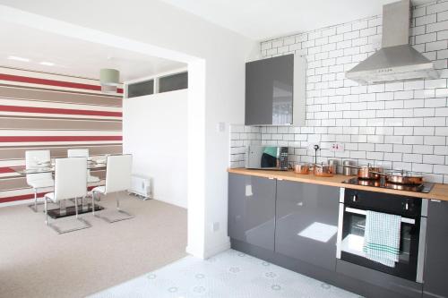 a kitchen with a counter and a table and chairs at Southside Apartment Glasgow in Glasgow