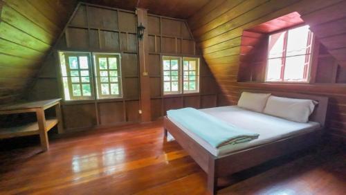 a bedroom with a bed in a wooden house at Babazia Community in Pai