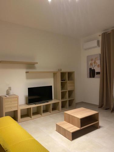 a living room with a tv and a yellow couch at Ma Home in Cinisi
