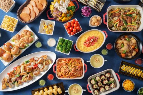 a table with many plates of food on it at Hotel Vista Kumamoto Airport in Ozu