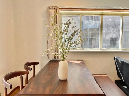 a vase with flowers sitting on a wooden table at New Sale! Tokyo Asakusa Area Emi House in Tokyo