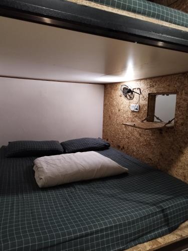 a bedroom with two beds and a mirror at Sleepbox Hotel in Cameron Highlands