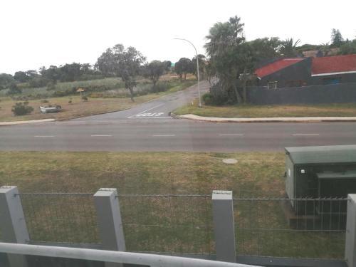 an empty road with a fence and a street at Luxury Living in Jbay in Jeffreys Bay