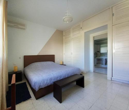 a bedroom with a bed and a bench in it at Villa Souad - havre de paix et charme tunisien aux portes de Tunis in La Marsa