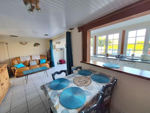 eine Küche und ein Esszimmer mit Tisch und Stühlen in der Unterkunft Cottage Le pêcheur du Grand Large proximité plage in Asnelles
