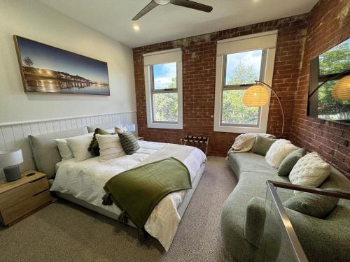 a bedroom with a bed and a couch at Mylan on Marine - Historic Charm, Modern Heart in Burnie