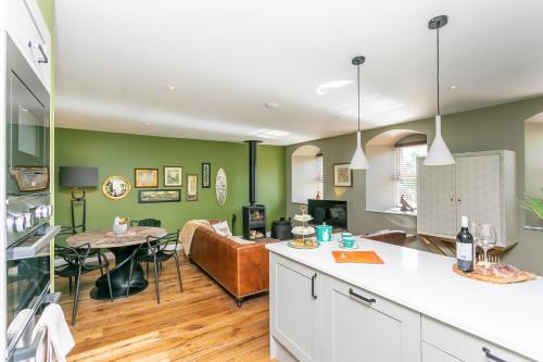 a kitchen and living room with green walls at Sunny Luxurious 2 bedroom Holiday cottage in Embsay