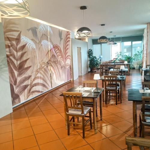 a restaurant with tables and chairs and a painting on the wall at Hotel Toscana in Figline Valdarno