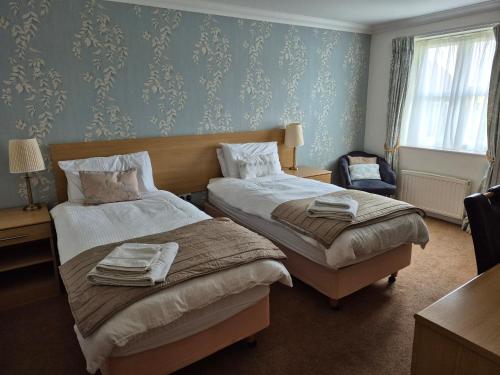 a hotel room with two beds with towels on them at Byards Leap Lodges in Welbourn