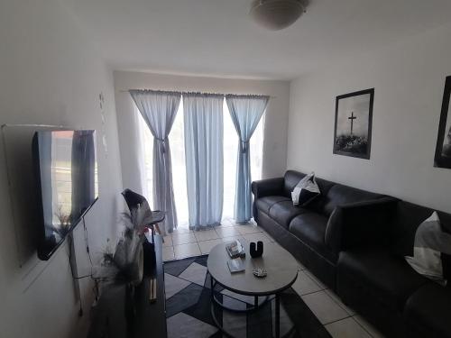 a living room with a couch and a table at Luxury Living in Jbay in Jeffreys Bay