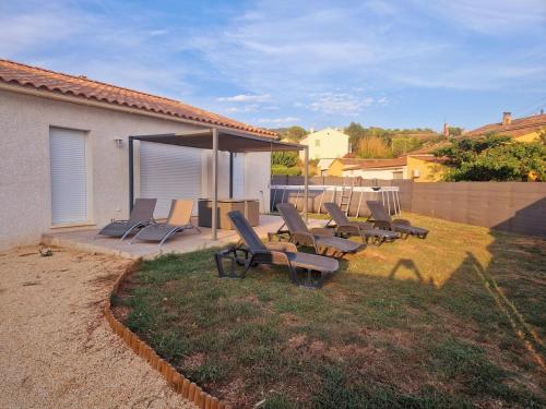 a group of lounge chairs sitting on a yard at Villa plain-pied au calme in Le Castellet