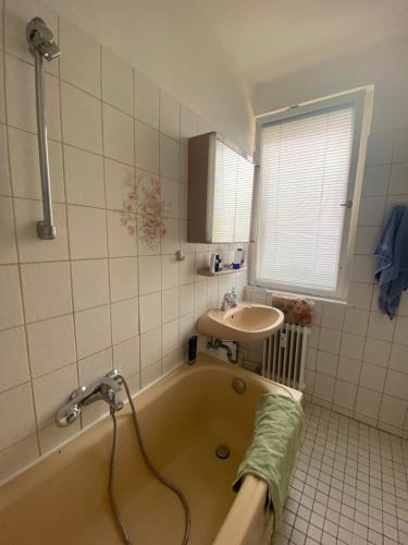 a bathroom with a tub and a sink at Cozy Apartment in Spandau Rauchstr with Garden View in Berlin