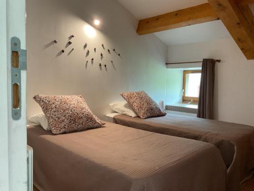 two beds in a room with birds on the wall at Les Gîtes La Chareyre in Thueyts
