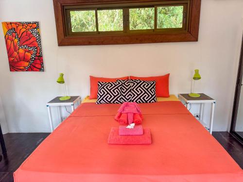 a bedroom with a large orange bed with two tables at Blessed Koh Chang in Ko Chang