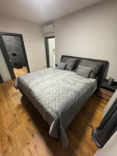 Una cama grande en una habitación con suelo de madera. en Tabáň Premium terrace apartment, en Nitra