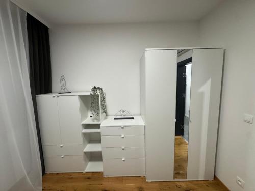 Vestidor blanco con espejo y tocador en Tabáň Premium terrace apartment, en Nitra