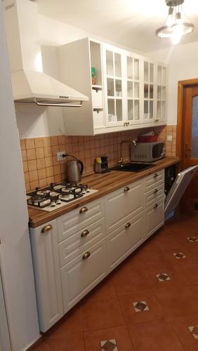 a kitchen with white cabinets and a stove top oven at Rogla Apartma Kekec in Zreče