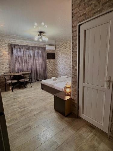 a bedroom with a bed and a table and a door at Panorama Gora in Kutaisi
