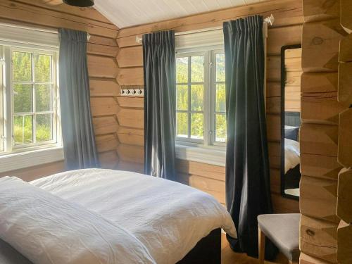 ein Schlafzimmer mit einem Bett in einer Blockhütte in der Unterkunft Log Cabin With Panoramic Views At Voss Resort in Skulestadmo