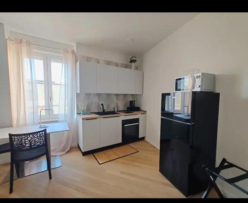 a small kitchen with a black refrigerator and a table at A Casa Di Ugo in Fisciano