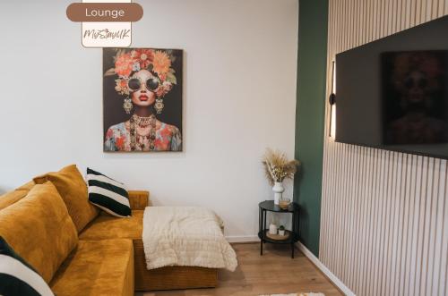 a living room with a couch and a painting of a woman at 3BR House By MyStayUK Short Lets & Serviced Accommodation Manchester With Free Parking & Contractor Stays in Manchester