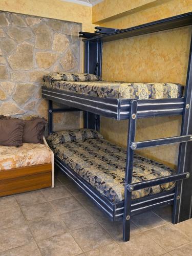 Cette chambre dispose de 3 lits superposés et d'un mur en pierre. dans l'établissement La depandance, à Castel di Sangro