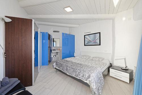 a bedroom with a bed and a blue cabinet at Casa Rondine by Fewotessin in Ronco s/Ascona - Porto Ronco