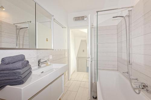 a white bathroom with a sink and a shower at Casa Rondine by Fewotessin in Ronco s/Ascona - Porto Ronco