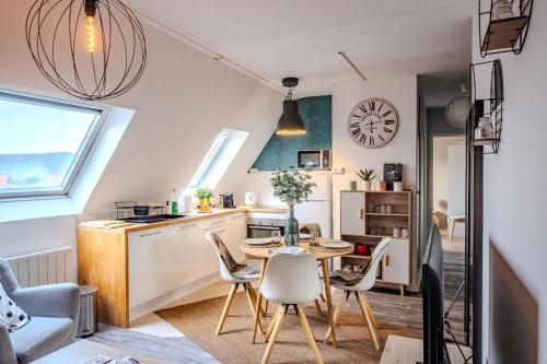 cocina pequeña y comedor con mesa y sillas en Cocon Sous les Toits - Proche Centre Ville - Parking Gratuit - Commerces à Proximité, en Sélestat