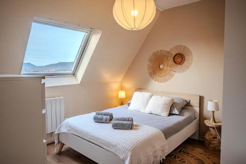 Un dormitorio con una cama y una ventana grande en Cocon Sous les Toits - Proche Centre Ville - Parking Gratuit - Commerces à Proximité, en Sélestat