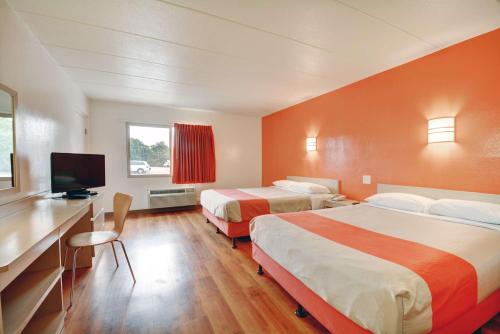 Habitación de hotel con 2 camas, escritorio y TV. en Motel 6-Seekonk, MA - Providence East, en Seekonk