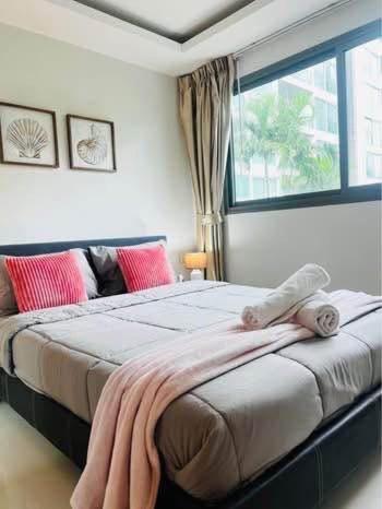 ein Schlafzimmer mit einem großen Bett mit Fenster in der Unterkunft Club Royal C324 in Pattaya North