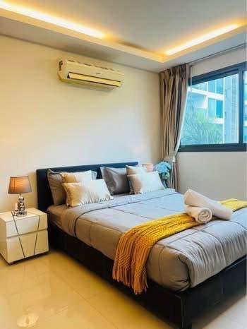 ein Schlafzimmer mit zwei Betten mit Fenster und Bettvolant in der Unterkunft Club Royal C324 in Pattaya North