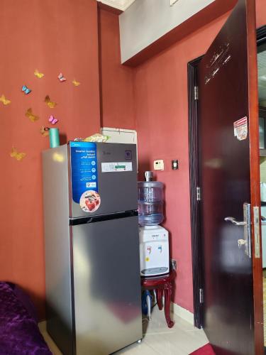 frigorifero in camera con parete rossa di استديو لشخصين ad Ajman
