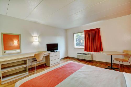 a room with a bed and a desk and a television at Motel 6-Seekonk, MA - Providence East in Seekonk