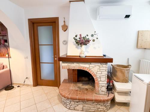 a living room with a brick fireplace with a vase of flowers at Casa Montebello in Camaiore