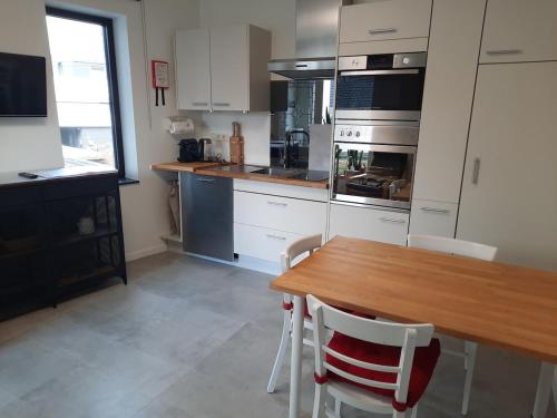 兰登Met een knipoog naar de fruitstreek!的配有木桌和白色橱柜的厨房