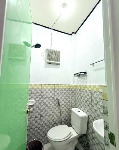 a bathroom with a toilet and a sink at Wakim’s INN in Coron