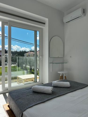 a bedroom with a bed and a large window at Greco Mare 99 in Kavos