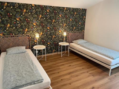 a room with two beds and a wall with a mural at Casa Colombina Duplex by Fewotessin in Gordola