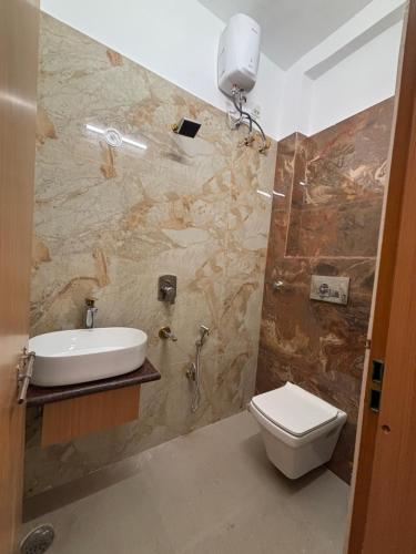 un baño con inodoro y lavabo en Awadh Savitri Homestay, en Faizābād