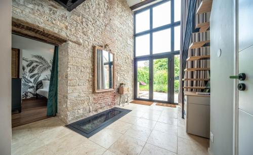 a large room with a brick wall and a fireplace at La Cave des Miracles in Dracy-le-Fort