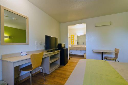 a room with a desk with a computer and a television at Motel 6-Camp Springs, DC - South Camp Springs in Camp Springs