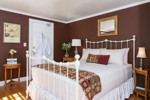 a bedroom with a white bed and brown walls at Inn on Putney Road in Brattleboro