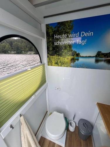 eine Toilette im Heck eines Bootes mit einem Fenster in der Unterkunft Hausboot Rollyboot Evolution 2- feste Unterkunft am Steg in Joachimsthal