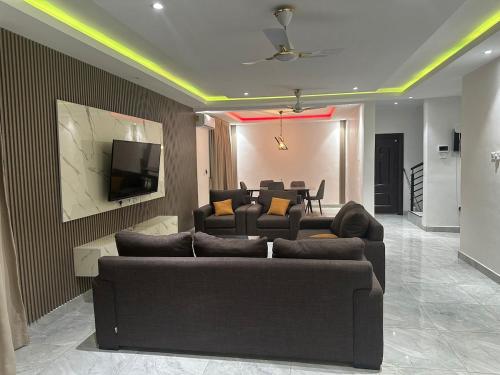 een woonkamer met een bank en een tv bij Entire home in Haatso in Ashonman